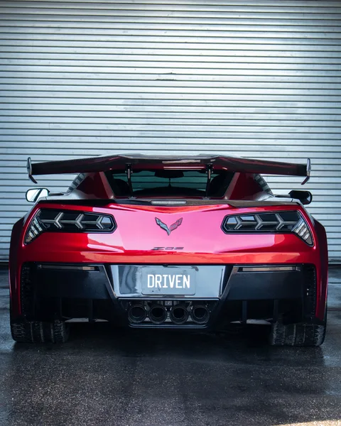 Red wrapped Corvette Z06 rear with DRIVEN plate and quad exhaust