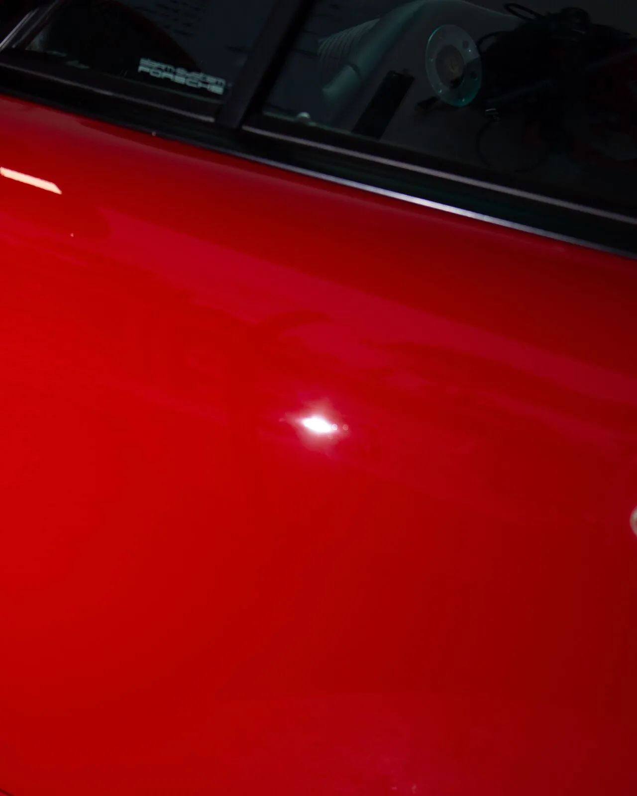 Red Porsche ceramic coating mirror finish close-up